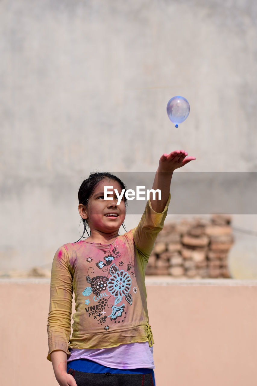 Girl playing with water bomb during holi