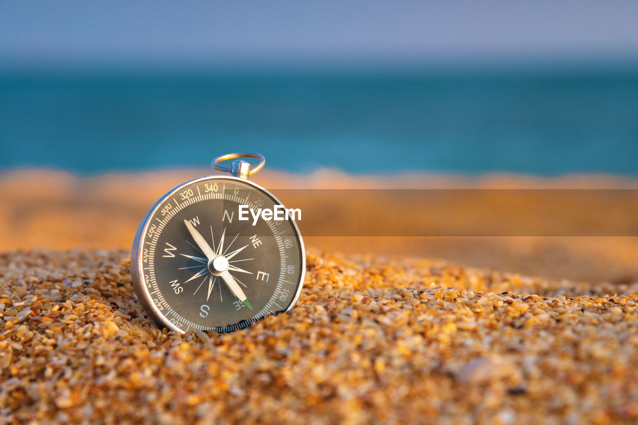 sea, land, beach, time, sand, water, nature, close-up, clock, watch, selective focus, no people, sky, travel, outdoors, yellow, day, wave, travel destinations, coastline, scenics - nature