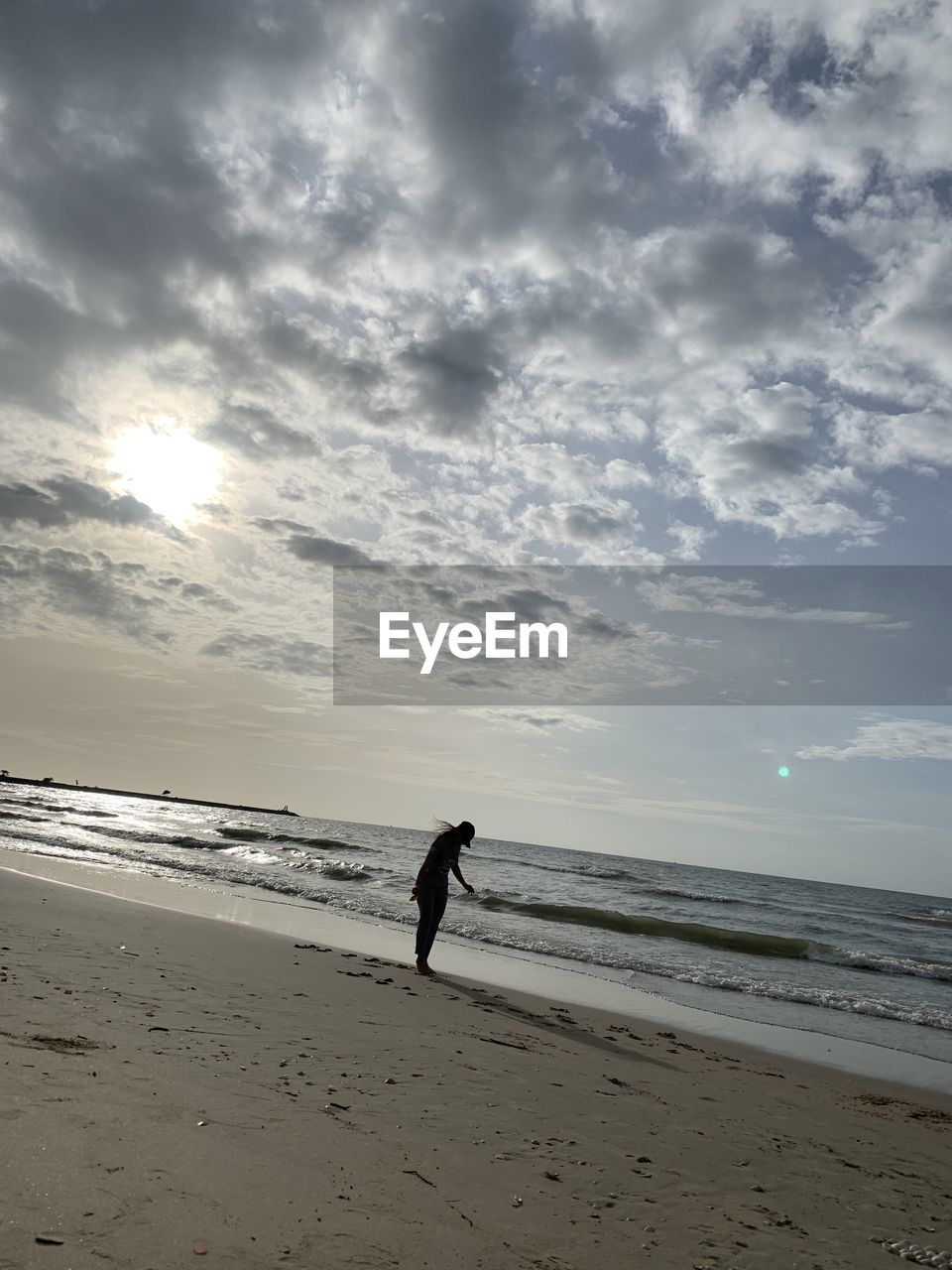 MAN ON BEACH AGAINST SKY DURING SUNSET