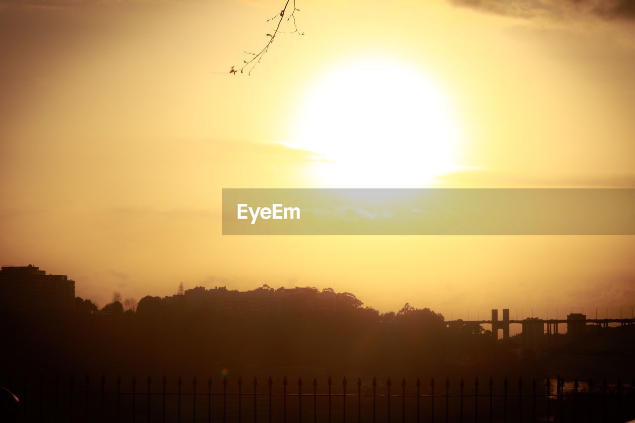 SILHOUETTE BUILDINGS AGAINST ORANGE SKY