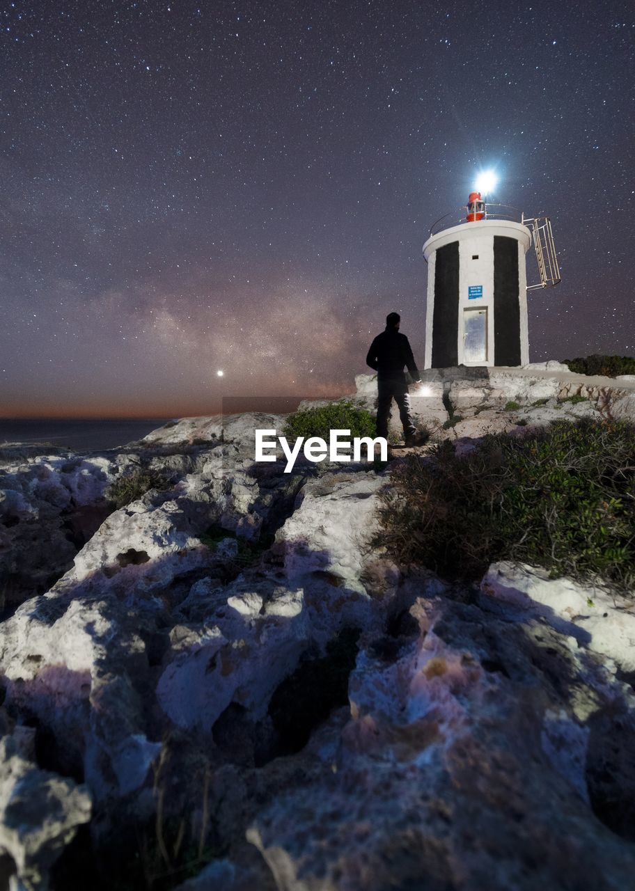 star, astronomy, lighthouse, space, night, sky, tower, galaxy, scenics - nature, science, star field, nature, astronomical object, milky way, space and astronomy, sea, architecture, rock, land, beach, moonlight, built structure, beauty in nature, water, constellation, landscape, guidance, long exposure, building exterior, building, environment, outer space, travel destinations, moon, exploration, illuminated, outdoors, planet, clear sky, coastline, travel, tranquility, astrology sign