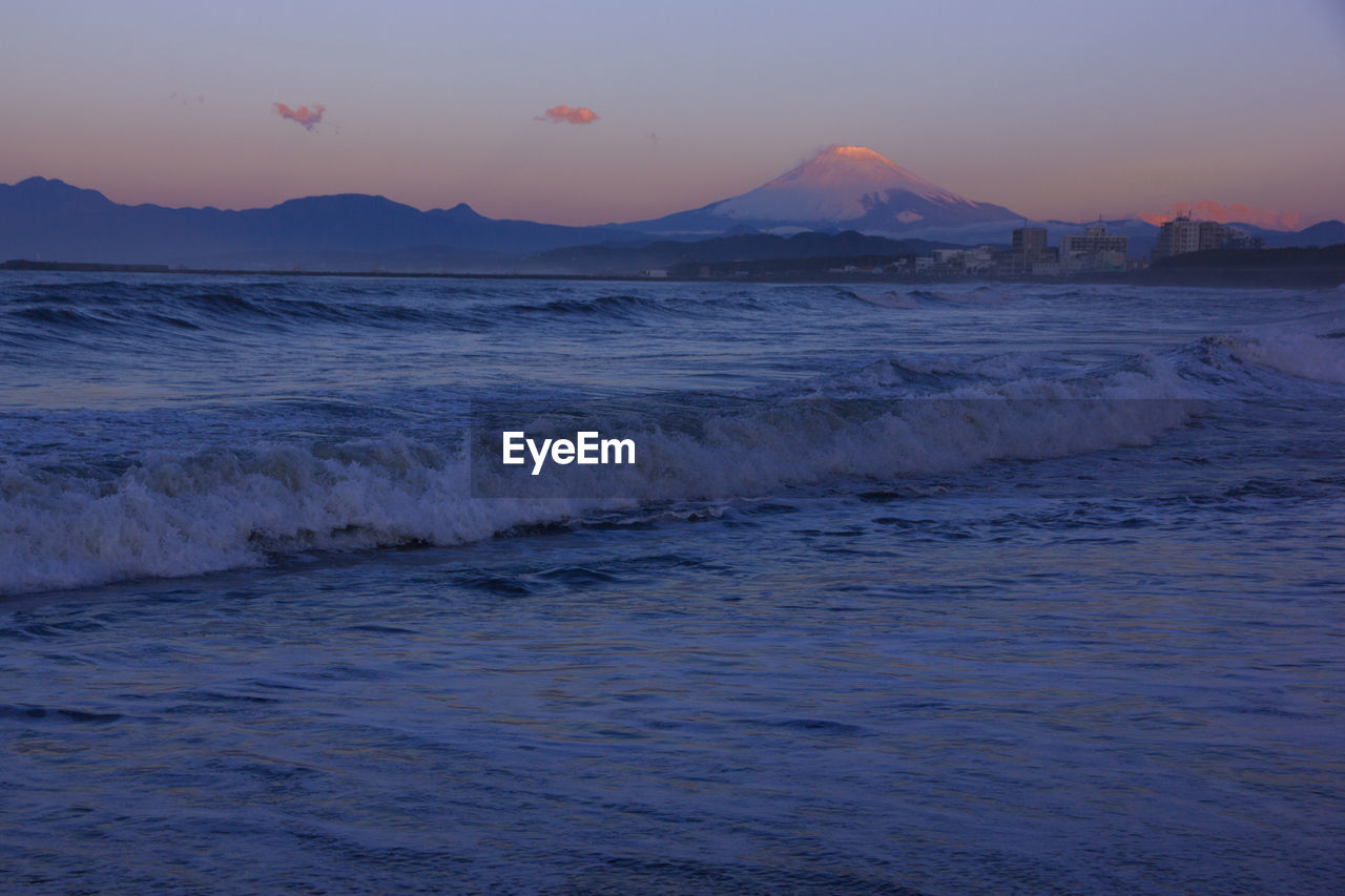 SCENIC VIEW OF BEACH AGAINST SKY DURING SUNSET