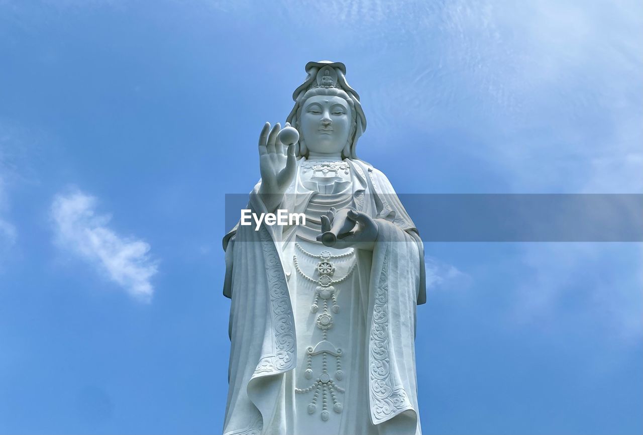 Low angle view of statue against blue sky