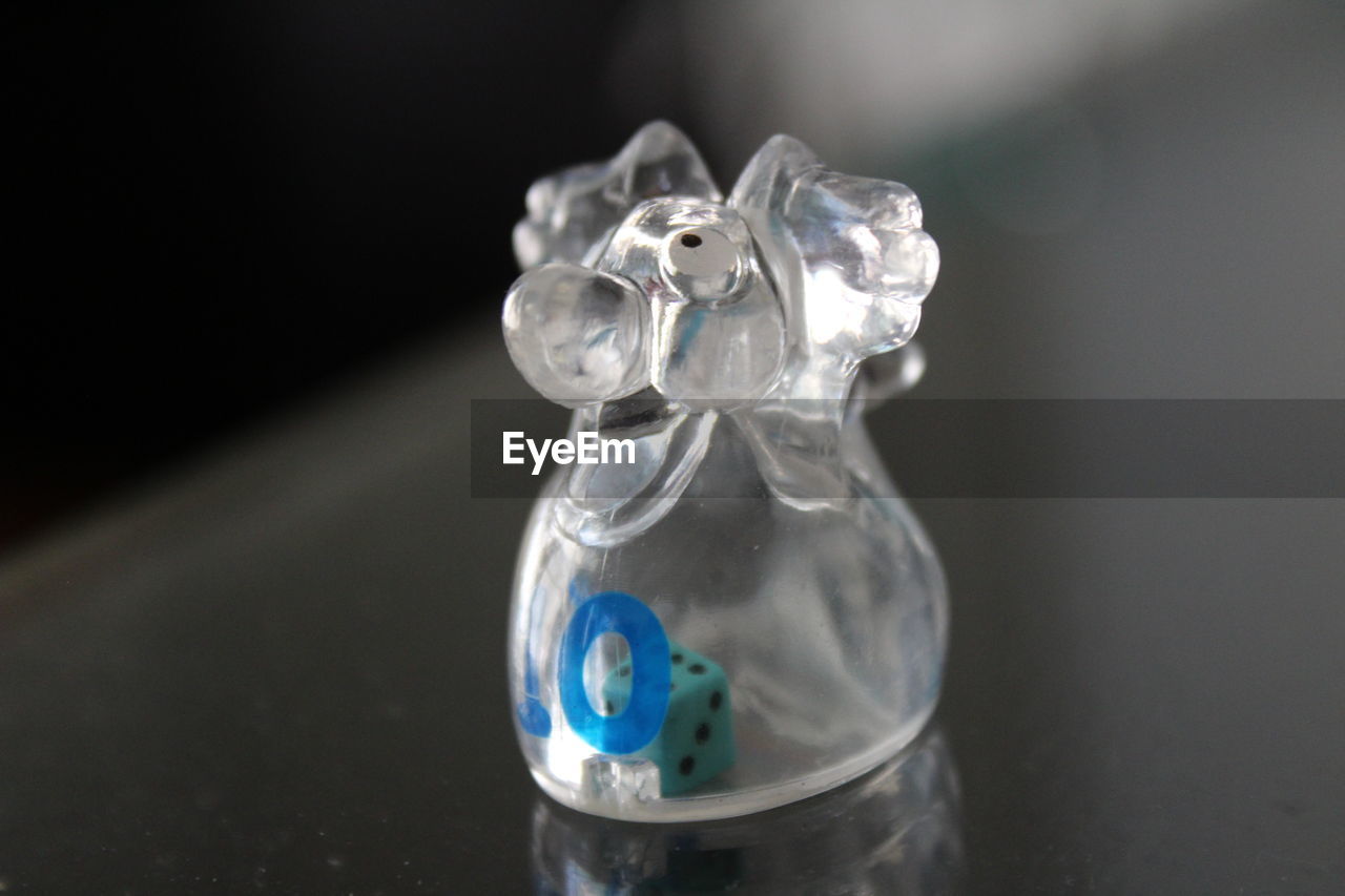 Close-up of glass container with dice on table