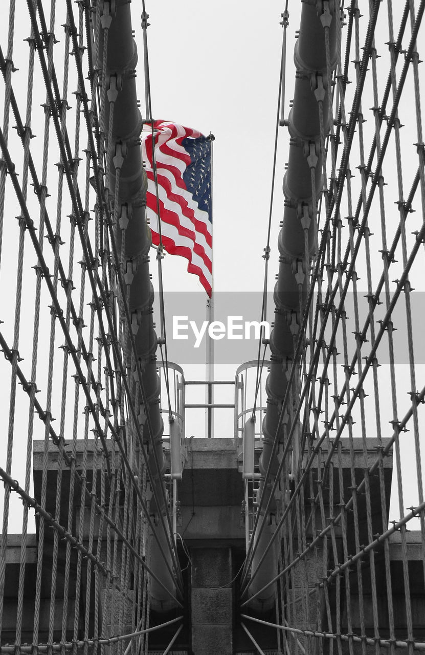 LOW ANGLE VIEW OF FLAG AGAINST BUILDINGS IN CITY