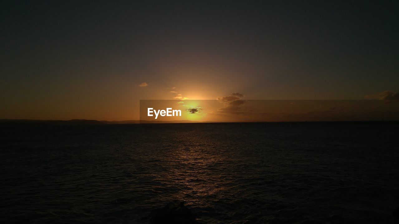 SCENIC VIEW OF SEA AGAINST ORANGE SKY DURING SUNSET