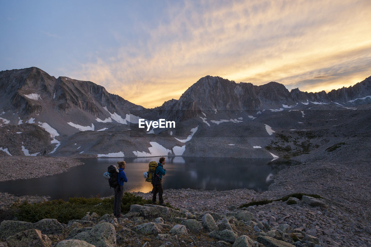 Women hikers watch sunset from pierre lakes, elk mountains, colorado