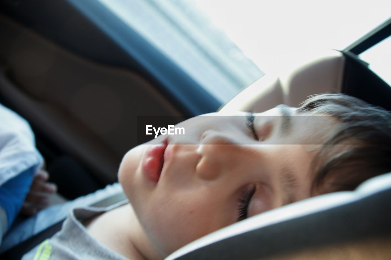 Close-up of boy sleeping in car