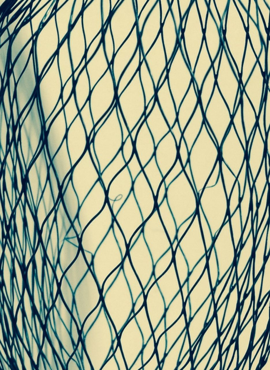 CLOSE-UP OF CHAINLINK FENCE AGAINST SKY