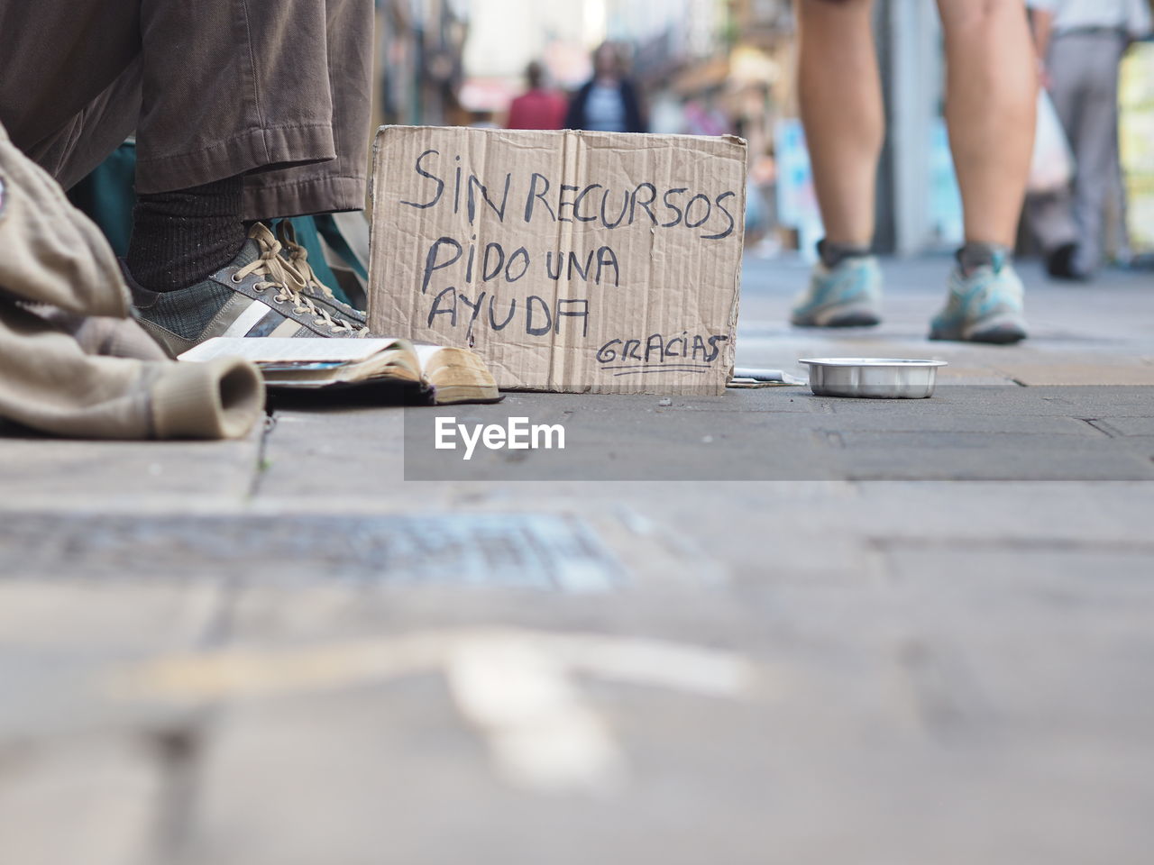 Low section of beggar with sign board on street