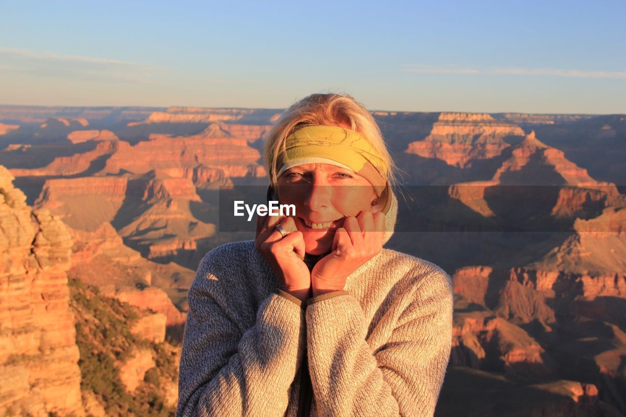 Portrait of woman standing against rocky mountains at grand canyon national park