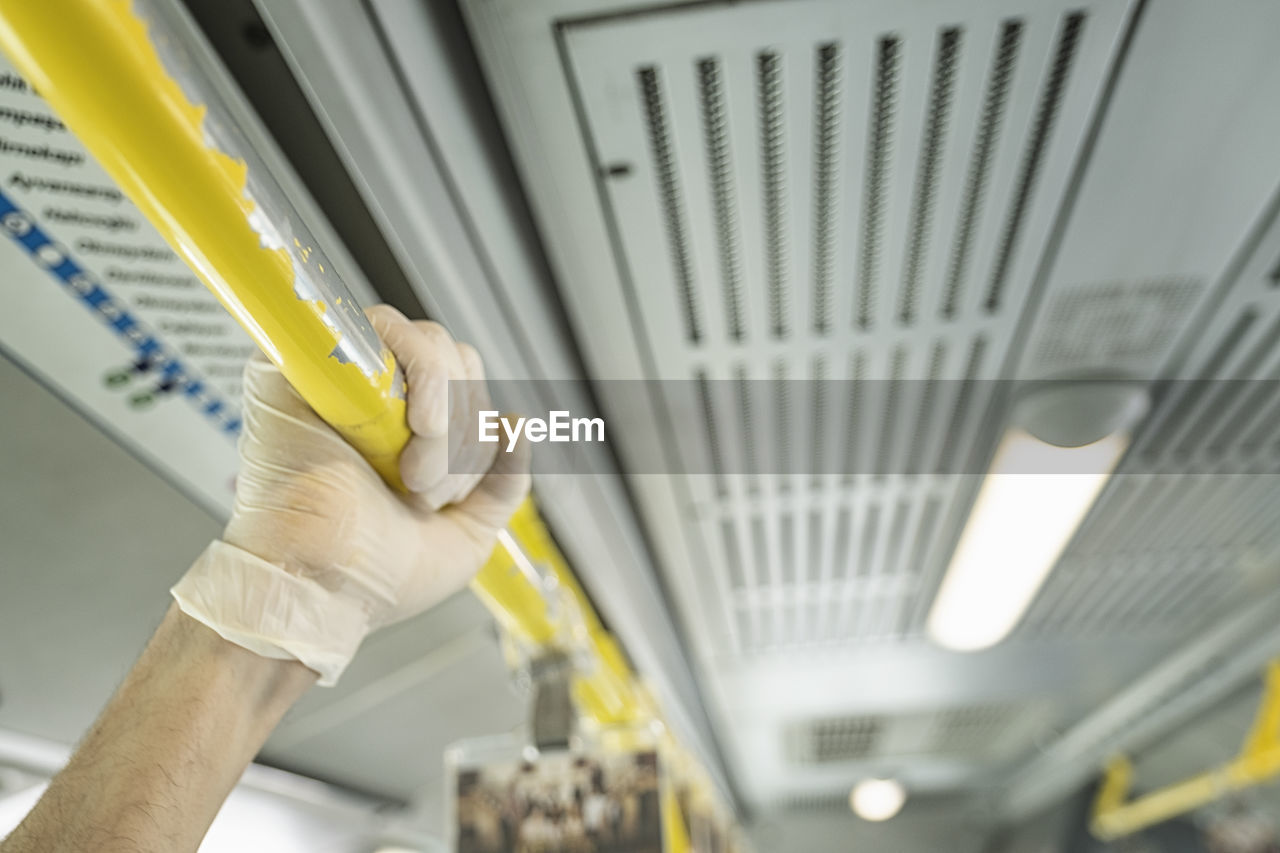 Close-up of hand holding machine part in bus