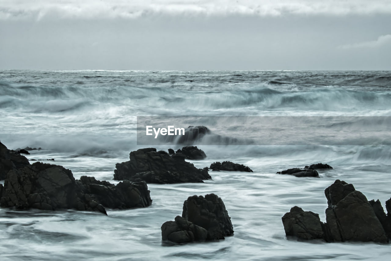 SCENIC VIEW OF ROCKS ON SHORE AGAINST SKY