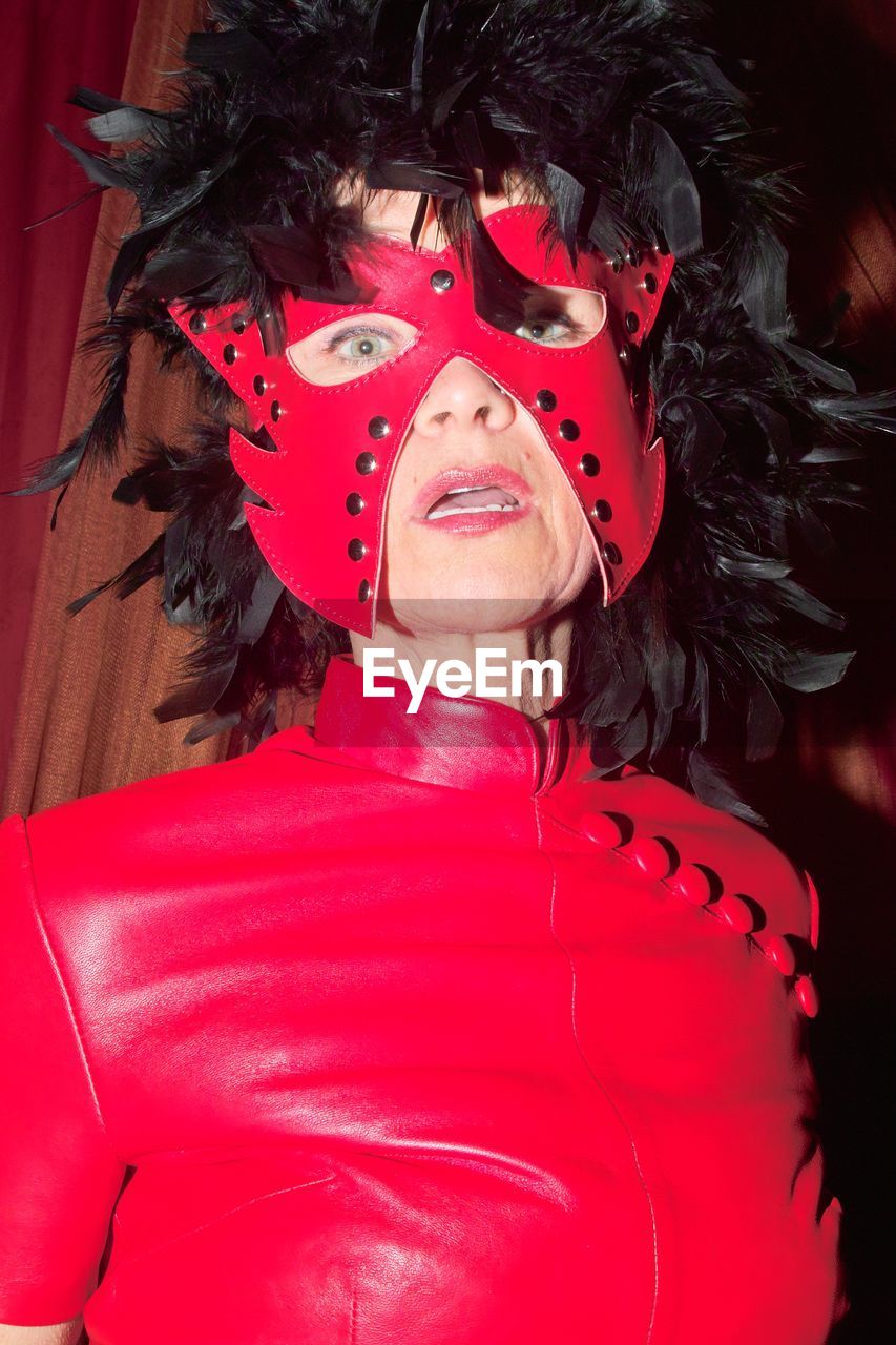 Portrait of woman wearing mask while standing in latex clothing 