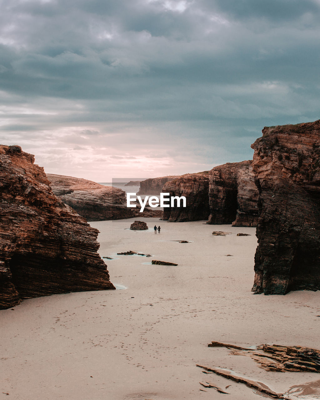 Rock formations on beach against sky