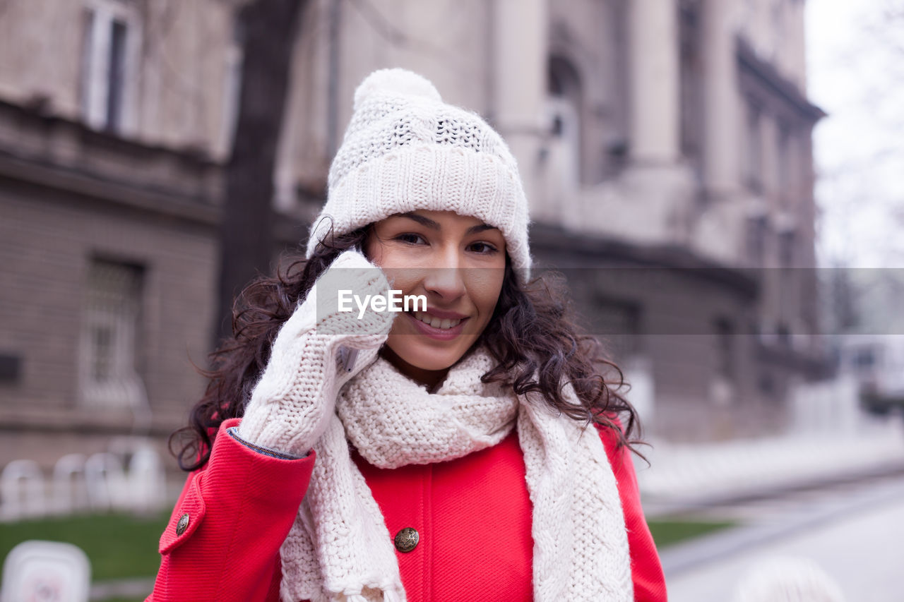 Portrait of young woman talking on smart phone in city