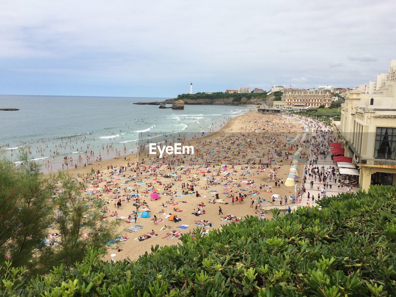 High angle view of people at beach against cloudy sky