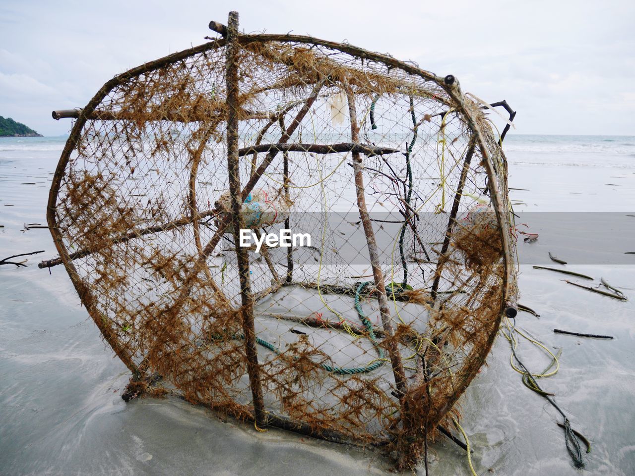 CLOSE-UP OF FISHING NET ON SEA SHORE