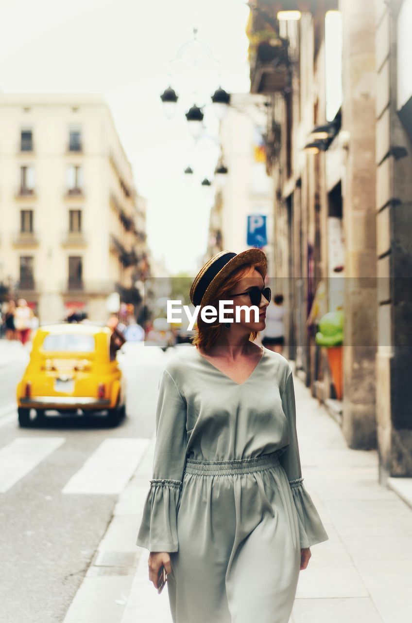 Young woman standing on street in city