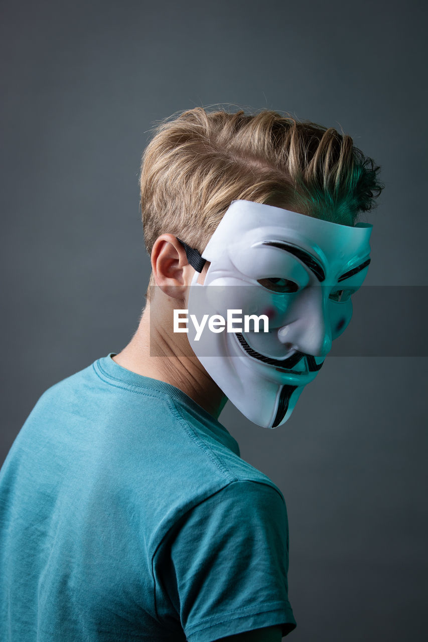 PORTRAIT OF BOY WEARING MASK AGAINST GRAY BACKGROUND