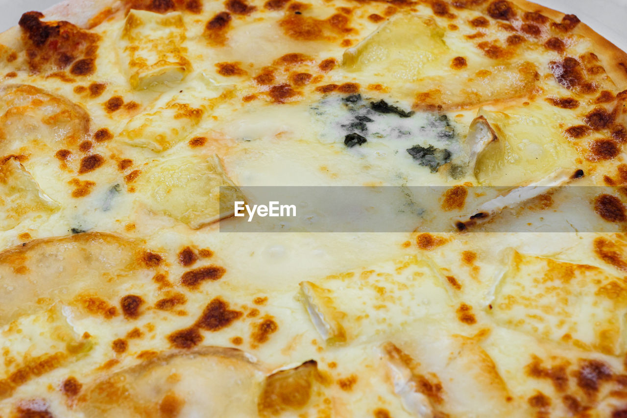 Close-up of pizza topped with different types of cheese. macro shot of delicious products. 