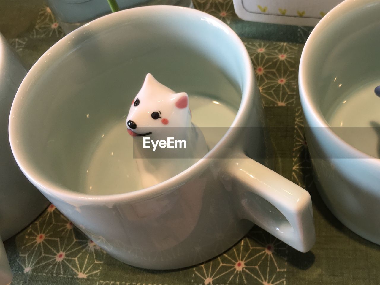 Close-up of animal figurine in cup on table