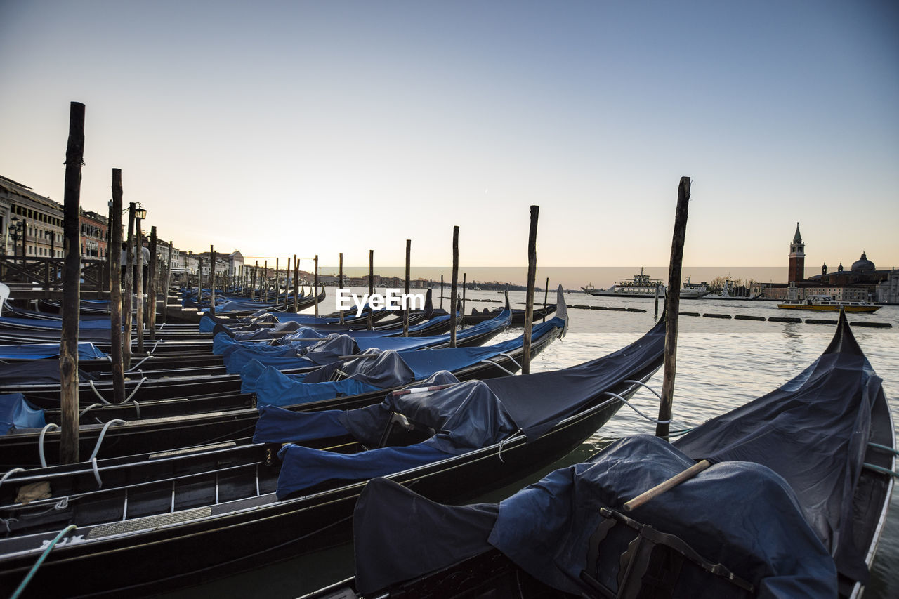 Gondola - traditional boat moored in san marco canal against sky during sunset
