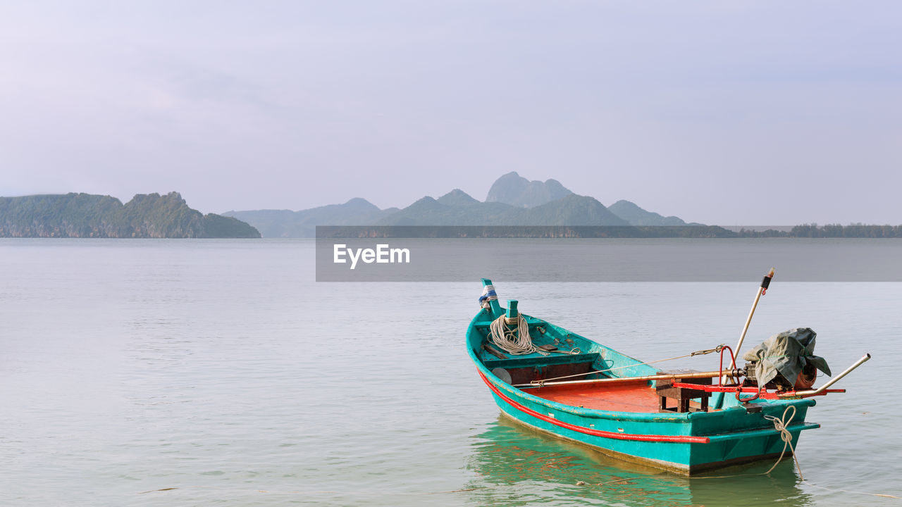 water, nautical vessel, transportation, sea, mode of transportation, boat, vehicle, nature, sky, land, travel, boating, mountain, scenics - nature, beach, tranquility, beauty in nature, long-tail boat, environment, landscape, travel destinations, tranquil scene, bay, watercraft, no people, outdoors, fishing, tourism, day, idyllic, holiday, tradition, trip, shore, coastline, vacation, moored, non-urban scene, reflection, occupation, seascape, fishing boat, activity, fishing industry, ship, island