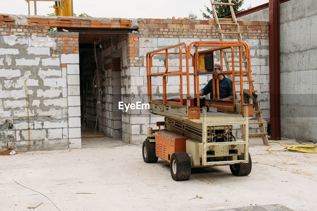 Scissor lift platform on a construction site. building concreate house with mobile transportation