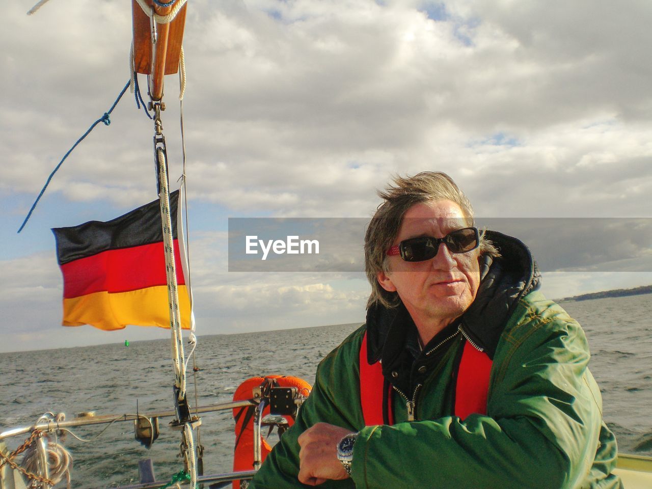 Man wearing sunglasses in boat on sea against sky