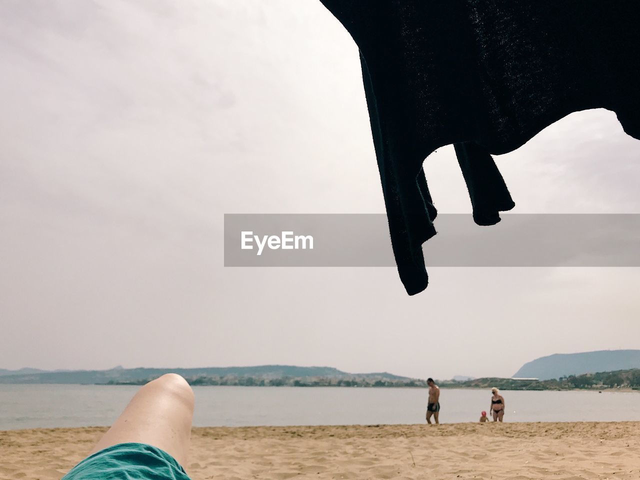 PEOPLE ON BEACH AGAINST SKY