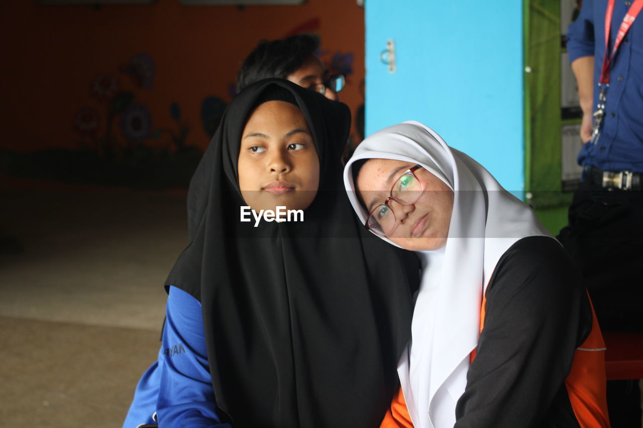 Portrait of woman sitting friend wearing hijab