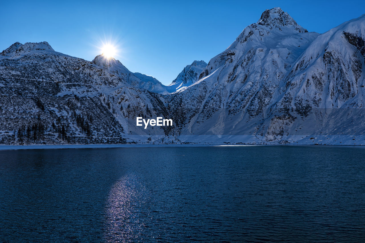 scenic view of snowcapped mountains against blue sky