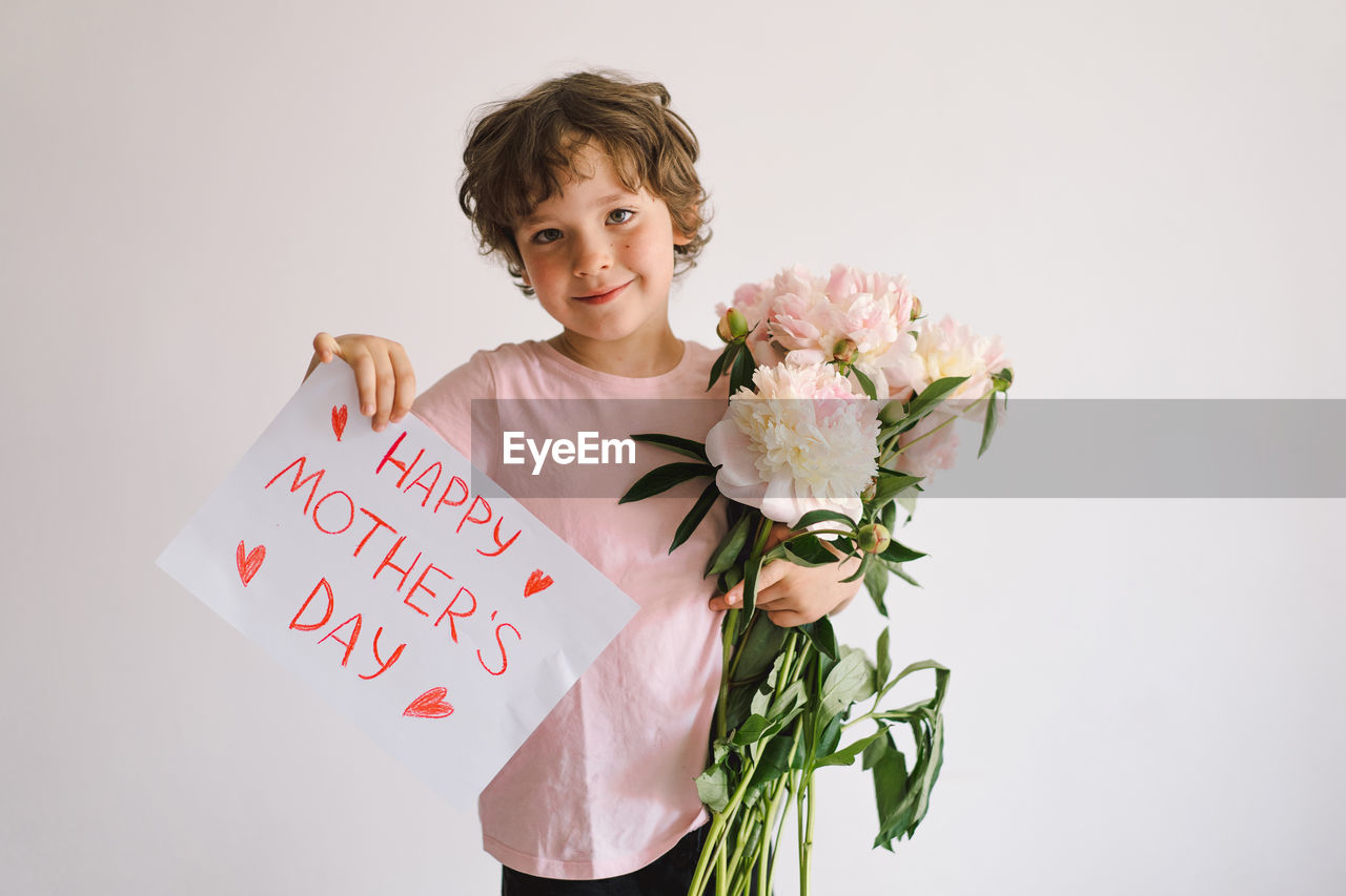 Happy mothers day. cheerful happy child with peonys bouquet.