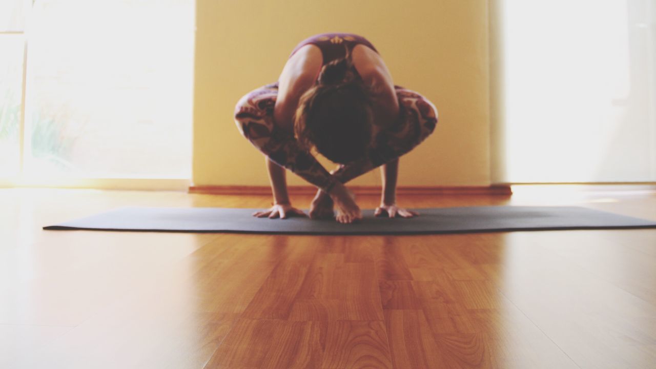 Full length of woman doing yoga at home