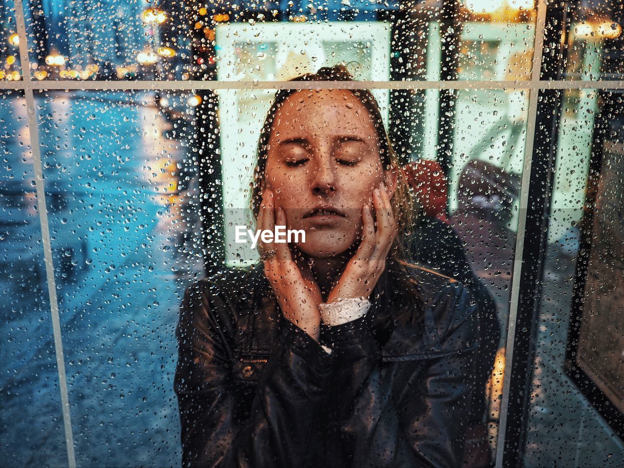 Woman seen through wet glass window
