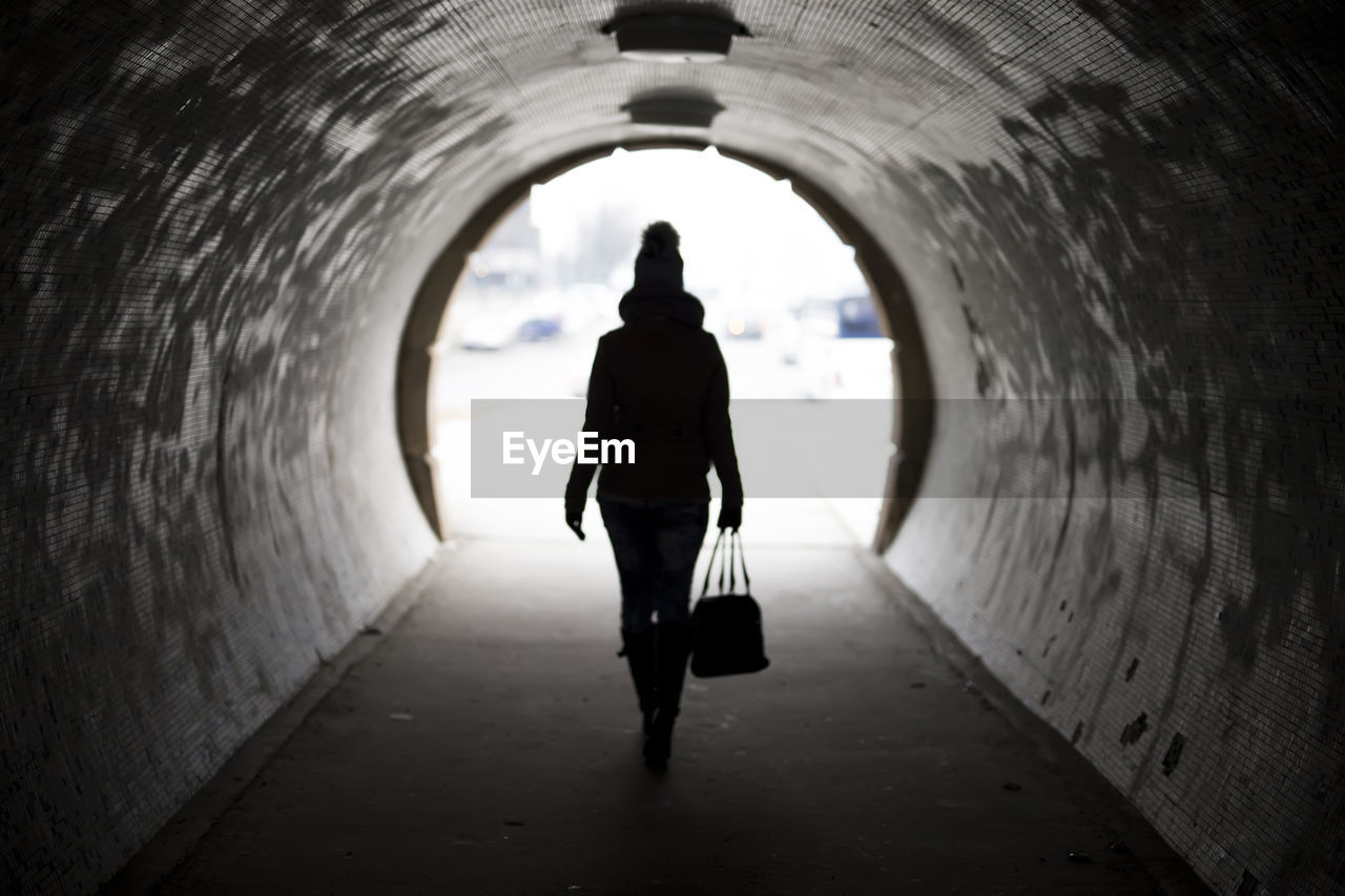 MAN WALKING IN TUNNEL