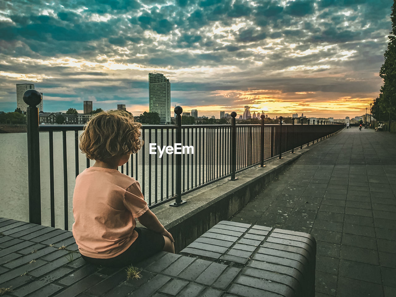 Boy contemplating sunset over london's skyline.  long road ahead