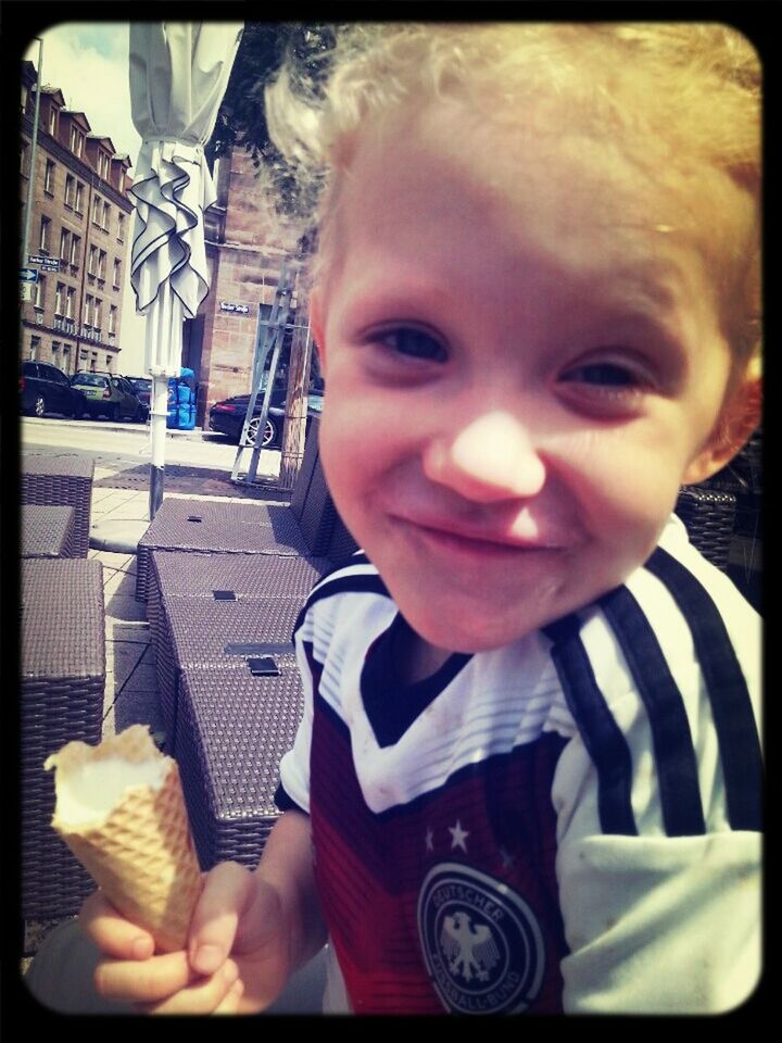 Portrait of cute girl having ice cream on sidewalk