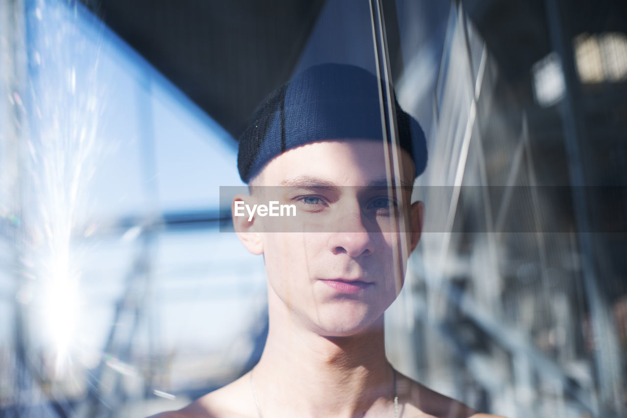 Close-up portrait of young man seen through window