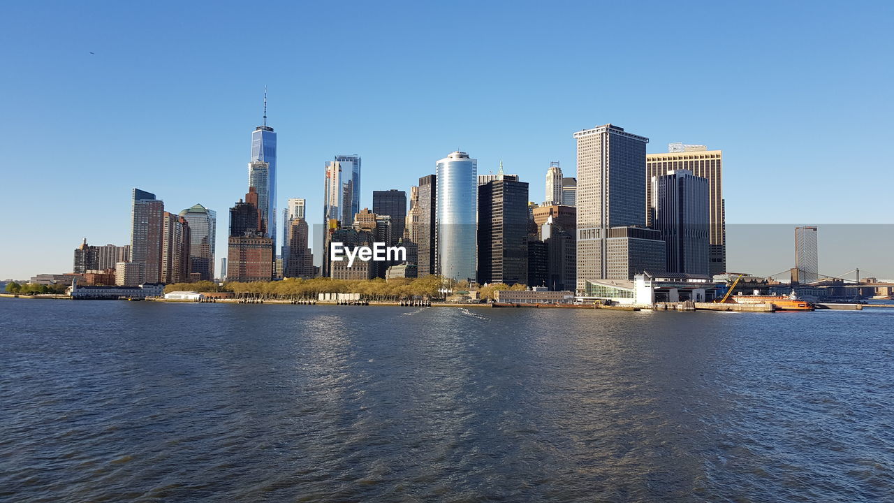 SEA BY BUILDINGS AGAINST CLEAR SKY IN CITY