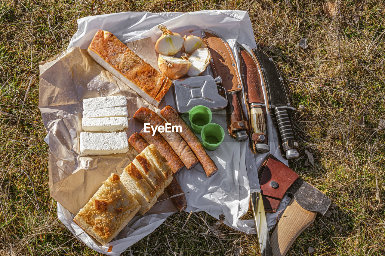 Romanian traditional food with sausages, onions and cheese and  ham, collection of knives and an axe