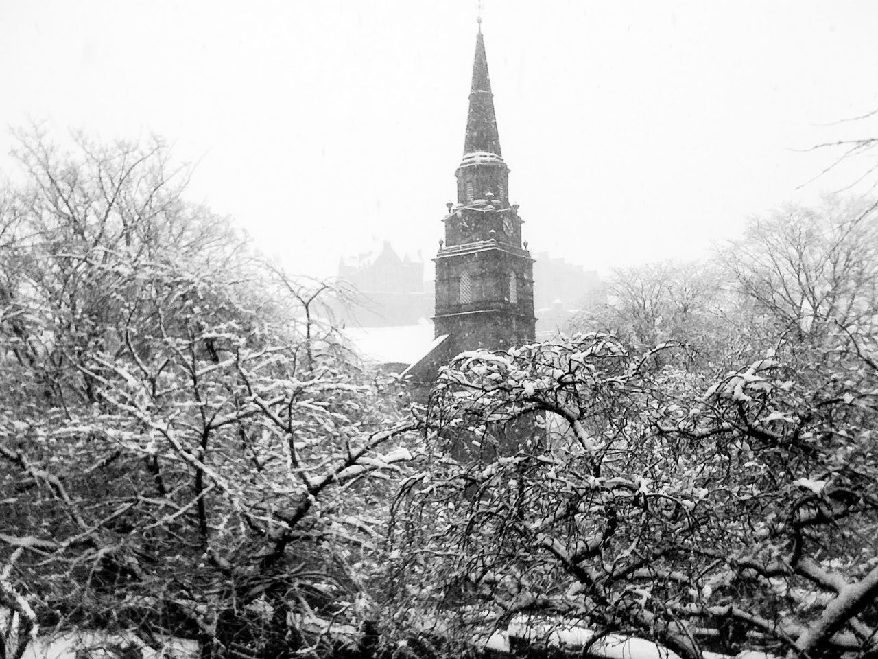 Low angle view of church and frozen trees against sky during foggy weather