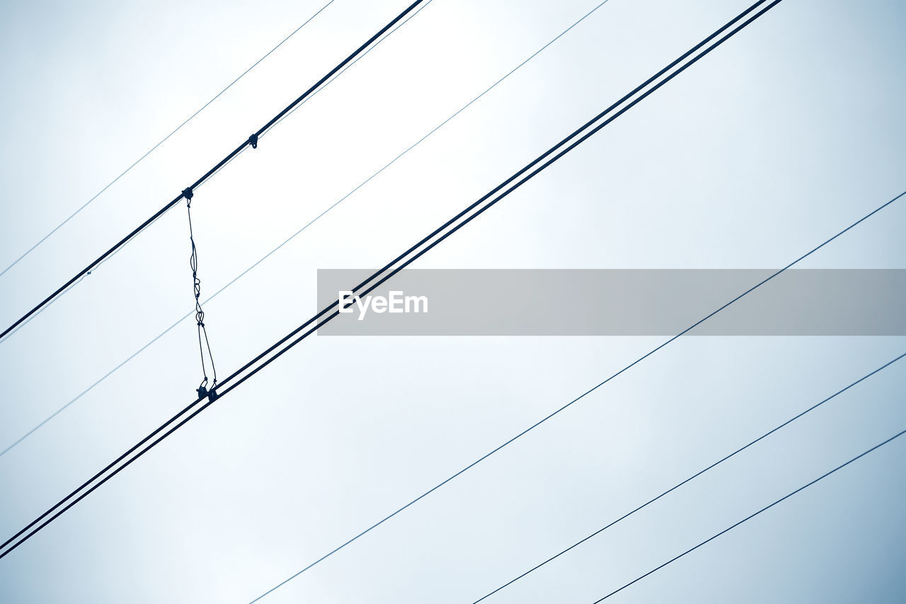 Low angle view of power lines against clear sky