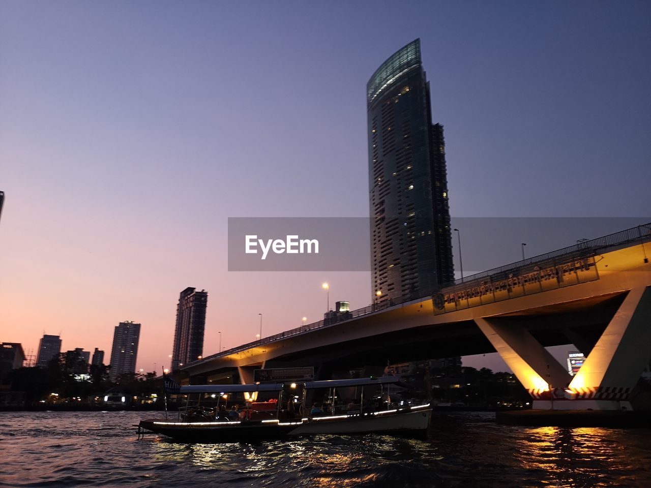 BRIDGE OVER RIVER IN CITY AGAINST CLEAR SKY