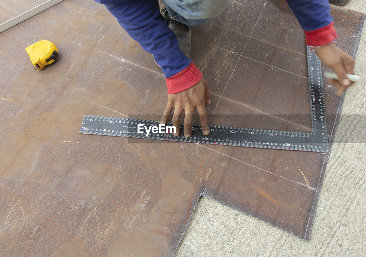 LOW SECTION OF MAN WORKING WITH TEXT ON FLOOR