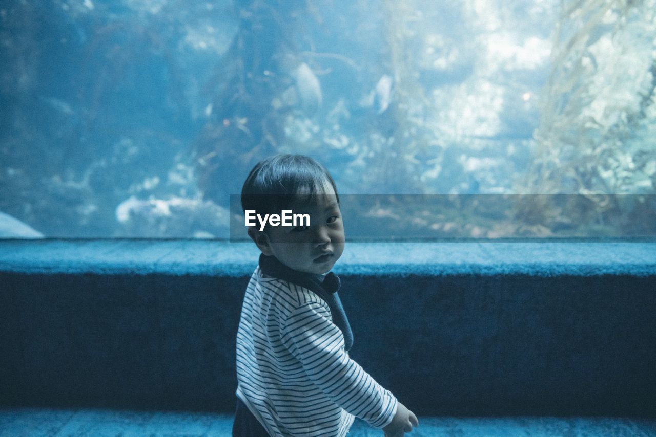 Portrait of boy standing at aquarium