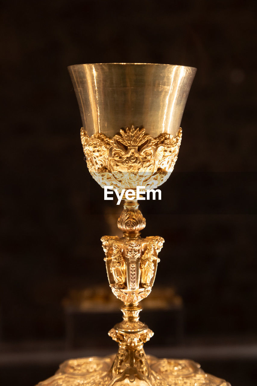 trophy, award, winning, success, glass, achievement, gold, lighting, indoors, single object, no people, alcoholic beverage, shiny, studio shot, luxury, wealth, competition, black background, close-up