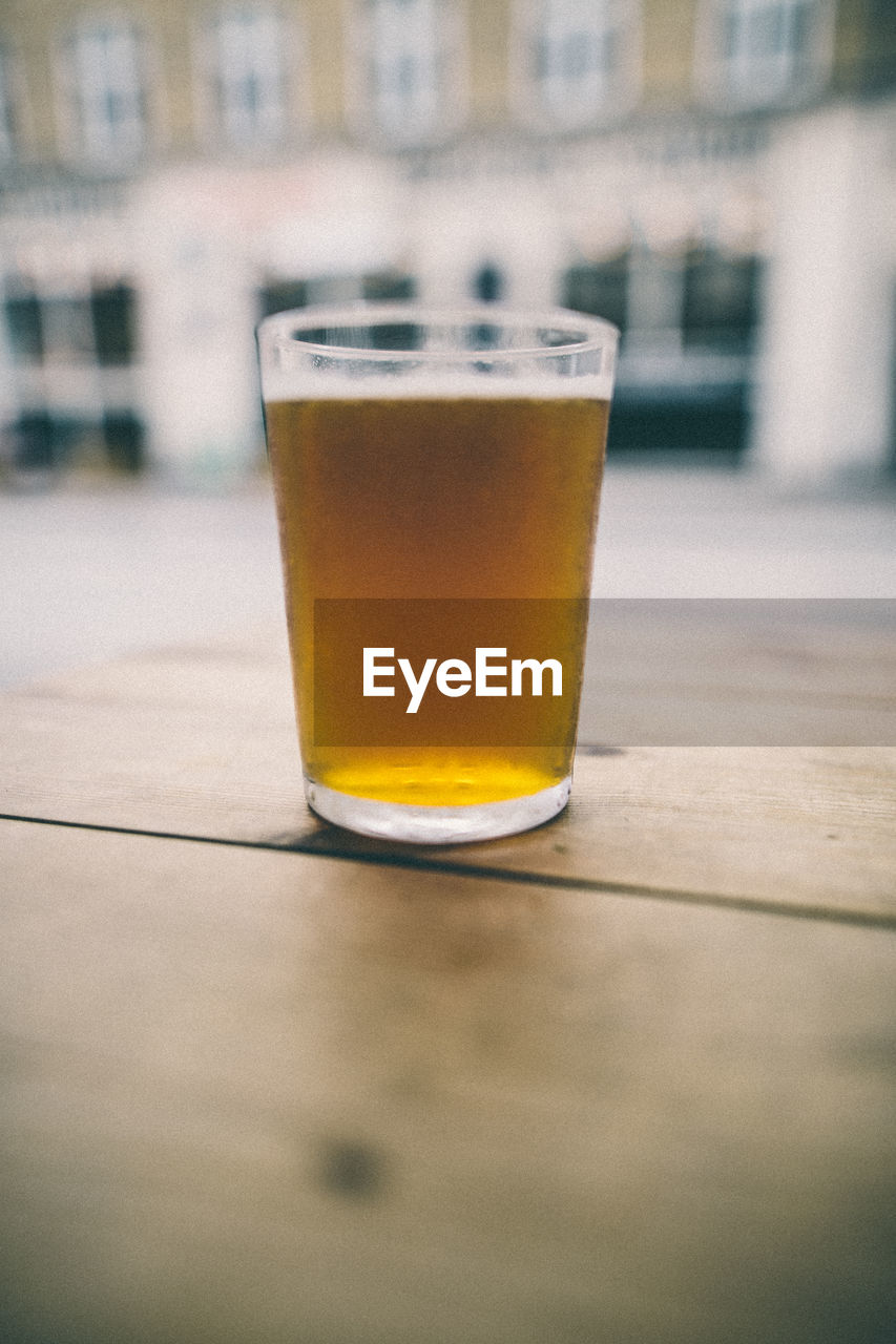 CLOSE-UP OF BEER GLASS ON TABLE