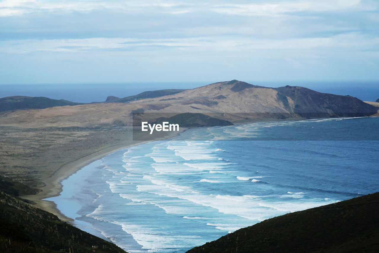 Scenic view of sea and mountains against sky